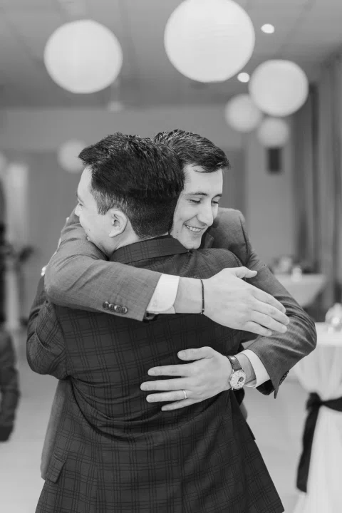 Dos hombres se abrazan en una fotografía en blanco y negro.