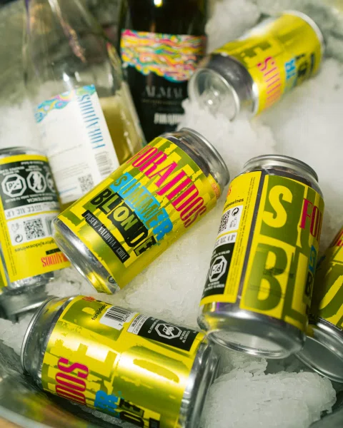 Latas amarillas Forajidos Summer Blonde enfriándose entre hielo.