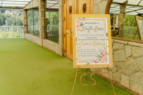 Cartel de bienvenida a la boda de Carla y Dharcy colocado sobre un caballete.