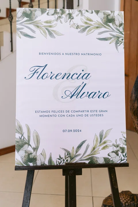 Cartel de bienvenida con los nombres Florencia y Álvaro dispuesto sobre un caballete.