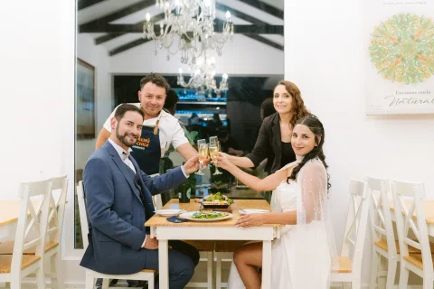 Cuatro personas levantan copas alrededor de una mesa.
