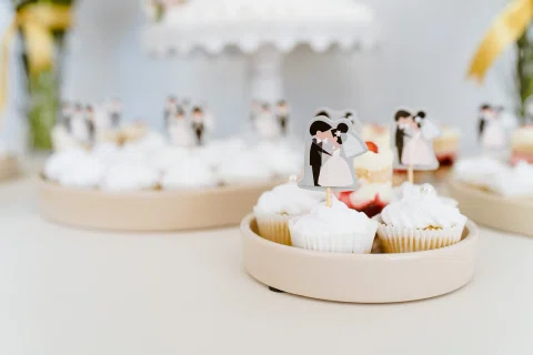 Cupcakes decorados con pequeñas figuras de dos personas sobre la cobertura.