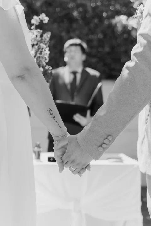 Detalle en blanco y negro de dos personas tomadas de las manos.
