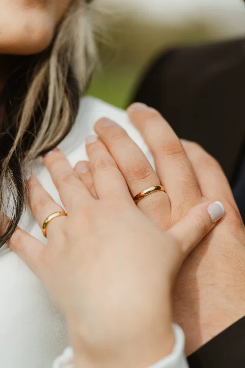 Detalle de dos manos unidas con anillos visibles.