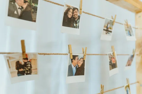 Fotografías pequeñas colgadas con pinzas sobre cordeles como parte de una decoración.