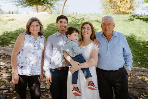 Cuatro adultos y un niño posan juntos al aire libre.