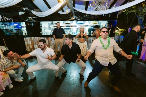 Grupo de hombres baila tomado de las manos en círculo.