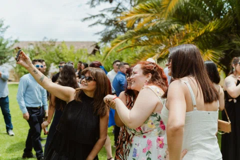 Grupo de mujeres posa para una fotografía tomada con un teléfono sostenido en alto.