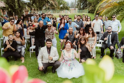 Grupo numeroso de personas posa sobre el césped.