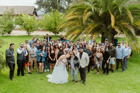 Grupo numeroso de personas posa junto sobre el césped.
