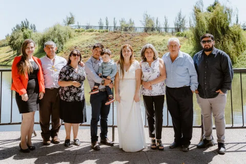 Grupo de personas con un niño posa junto a una baranda en un parque.