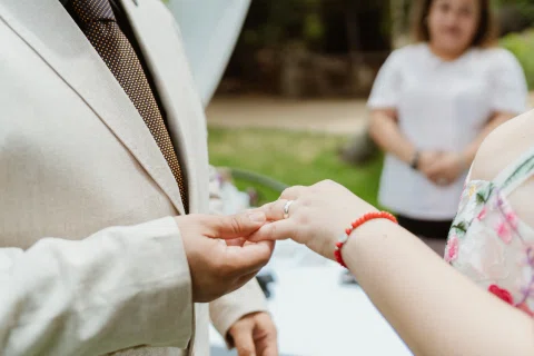 Primer plano de un hombre colocando un anillo en la mano de una mujer.