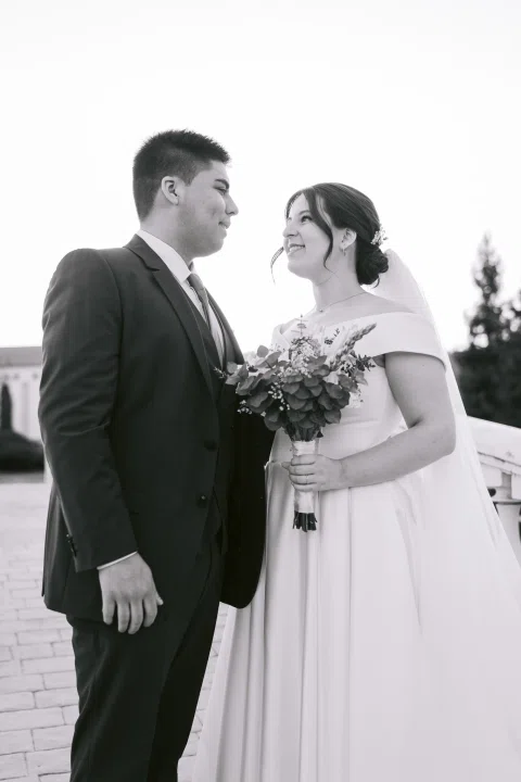 Hombre y mujer posan juntos en un retrato cercano en blanco y negro.