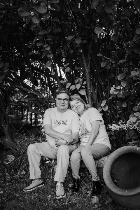 Hombre y mujer sentados juntos en un jardín, en una fotografía en blanco y negro.