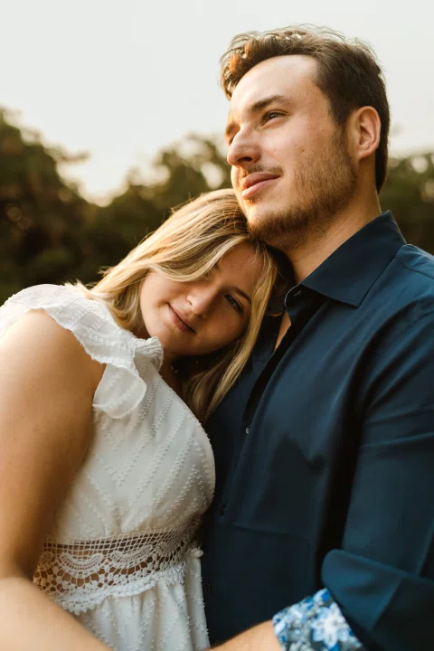 Hombre sonriendo mientras la mujer apoya la cabeza sobre su pecho.