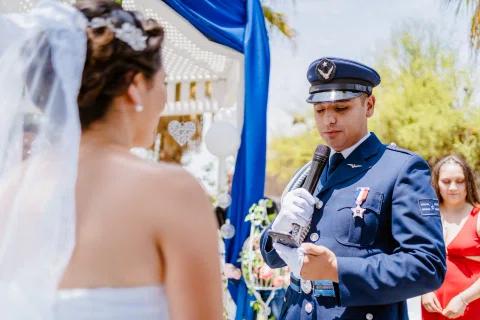 Hombre con uniforme azul leyendo un documento frente a la mujer.
