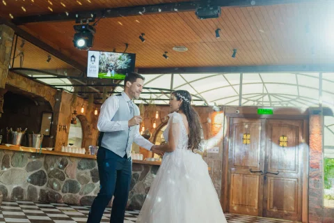 Hombre y mujer bailan tomados de la mano en el centro del salón.