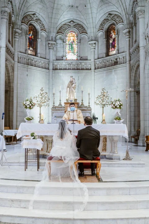 Vista amplia del interior de una iglesia con dos personas frente al altar.