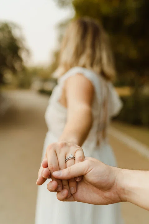 Primer plano de las manos de un hombre y una mujer tomadas entre sí.