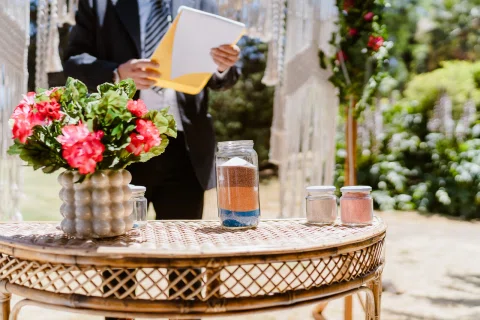 Mesa de ceremonia decorada con flores, vasos y pequeños recipientes.