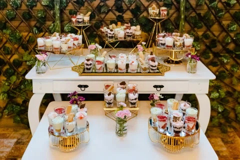 Mesa de dulces y postres fotografiada desde un ángulo alto.