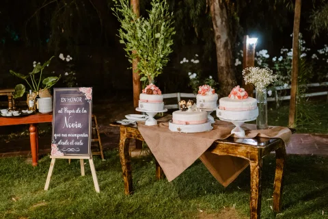 Mesa de postres dispuesta al aire libre durante la noche.