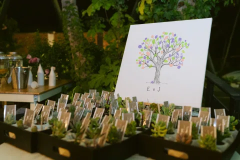 Mesa con pequeñas tarjetas fotográficas y una lámina decorativa de un árbol.