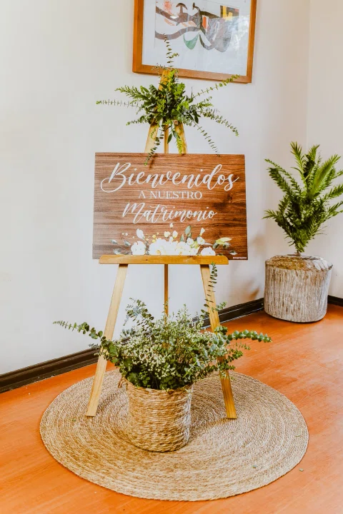 Mesa pequeña con una torta decorada y arreglos florales en interior.