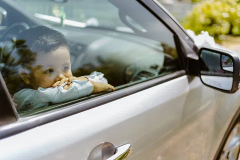 Niño mirando a través de la ventana de un auto desde el asiento interior.
