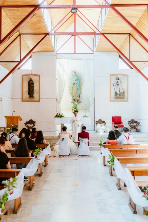 Vista amplia del pasillo de una iglesia con personas sentadas a ambos lados.