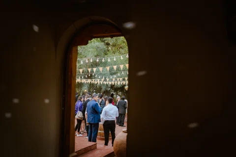Personas visibles a través de una puerta oscura en un encuadre desde el interior.
