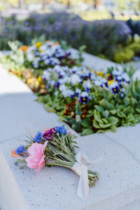 Ramo de flores coloridas apoyado sobre una superficie de piedra.