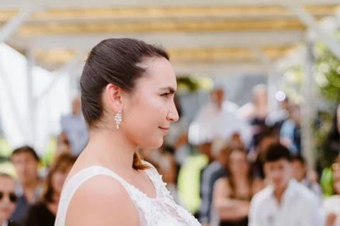 Retrato de perfil de una mujer con vestido blanco y cabello recogido.