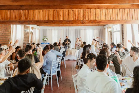 Vista amplia de un salón con numerosas personas sentadas y varias manos levantadas.