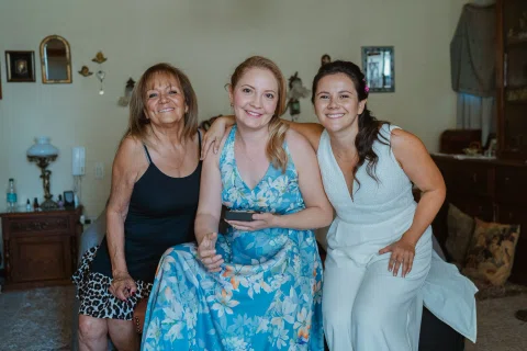 Tres mujeres posando juntas dentro de la habitación durante los preparativos.